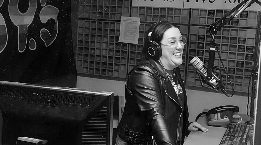 Harmony Soleil in a radio studio speaking on the mic while laughing