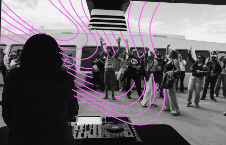 A person stands at a DJ booth on a deck, entertaining a cheering crowd on a cruise ship. Curved, purple lines overlay the image, adding a dynamic effect. The background shows the ship's structure and a cloudy sky.
